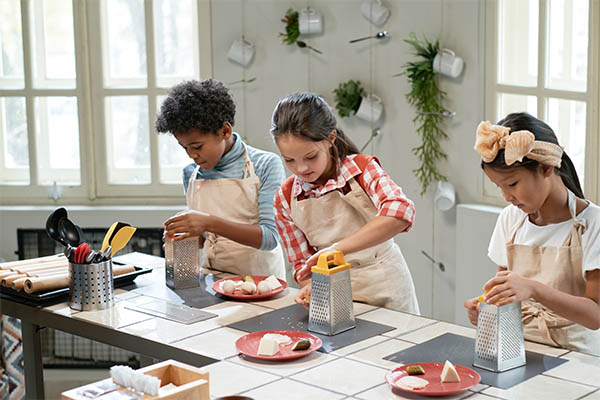 Students in aprons preparing food during a culinary skills class